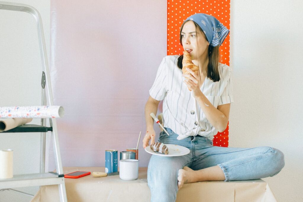 Woman in White Shirt and Blue Denim Jeans Sitting on White Plastic Seat